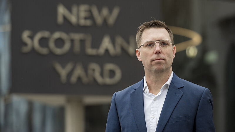Rob Blackie pictured in a navy blazer with a white shirt outside New Scotland Yard