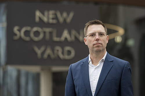 Rob Blackie pictured in a navy blazer with a white shirt outside New Scotland Yard