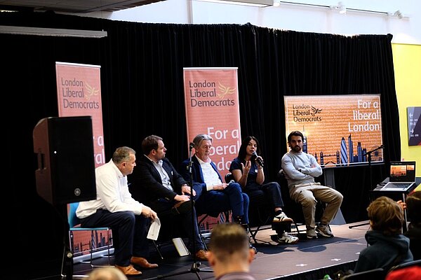 An image of the 2025 London Lib Dem Conference Stage, with speakers including Chris Maines, Luke Taylor MP, Paul Kohler MP, Sarah Olney MP and Bobby Dean MP